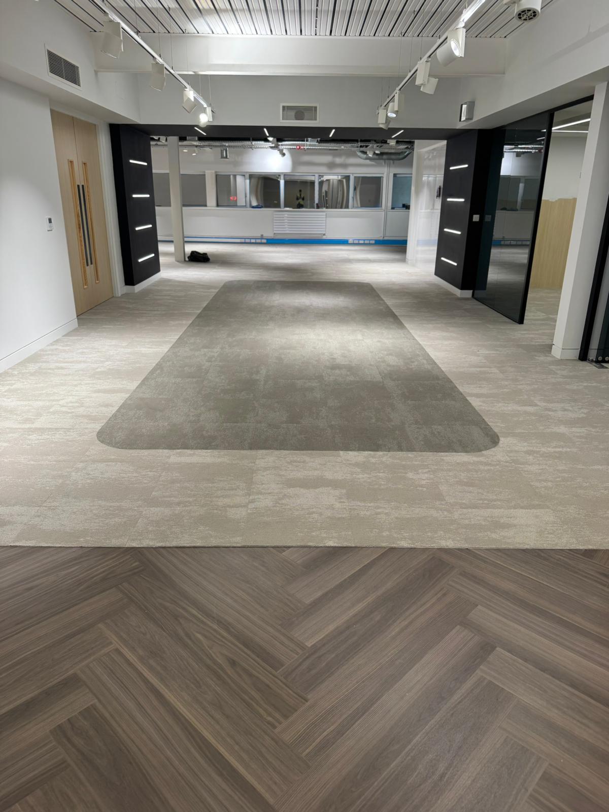 Large office with herringbone wood and carpet tile transition