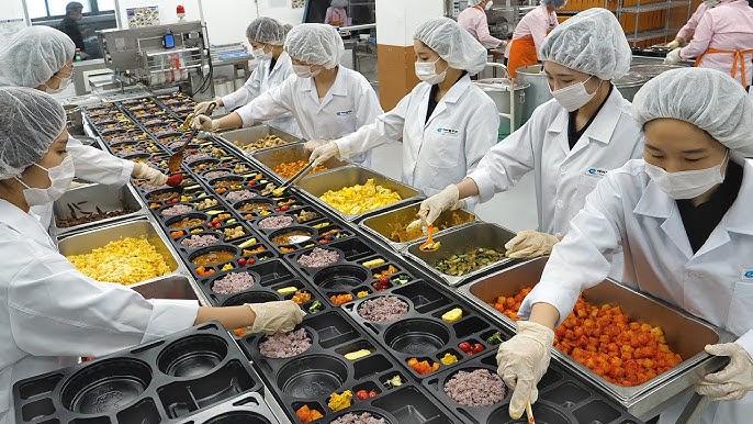 Commercial kitchen production line showing meal prep assembly process