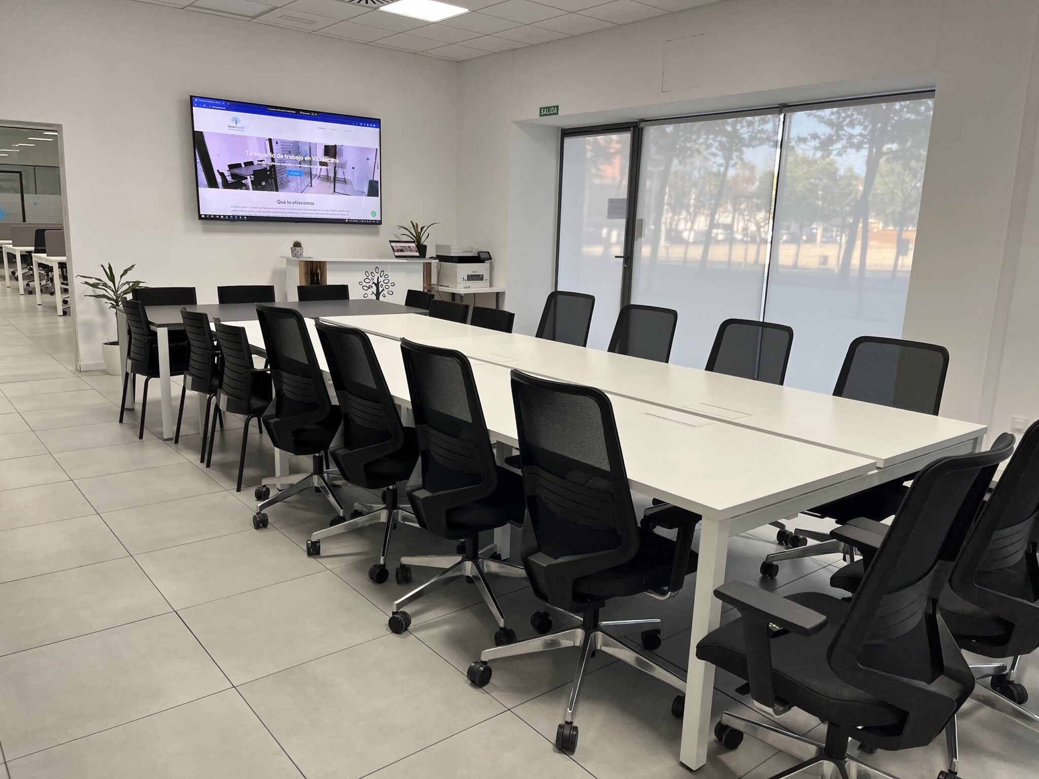 Sala de formación y eventos en Viladecans con mesas modulares, pantalla y sillas