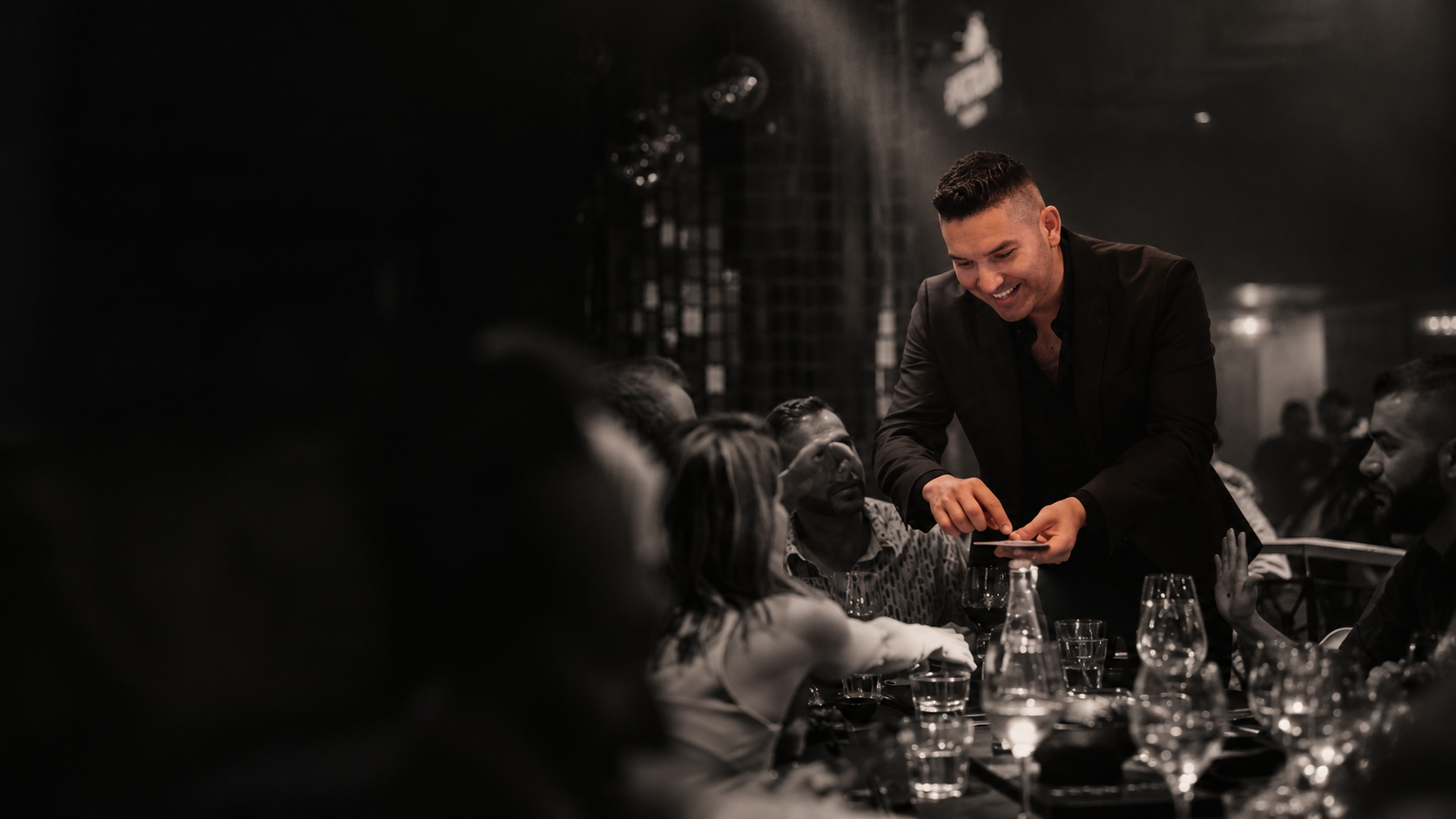 Alvaro Quevedo performing close-up magic at a dinner party