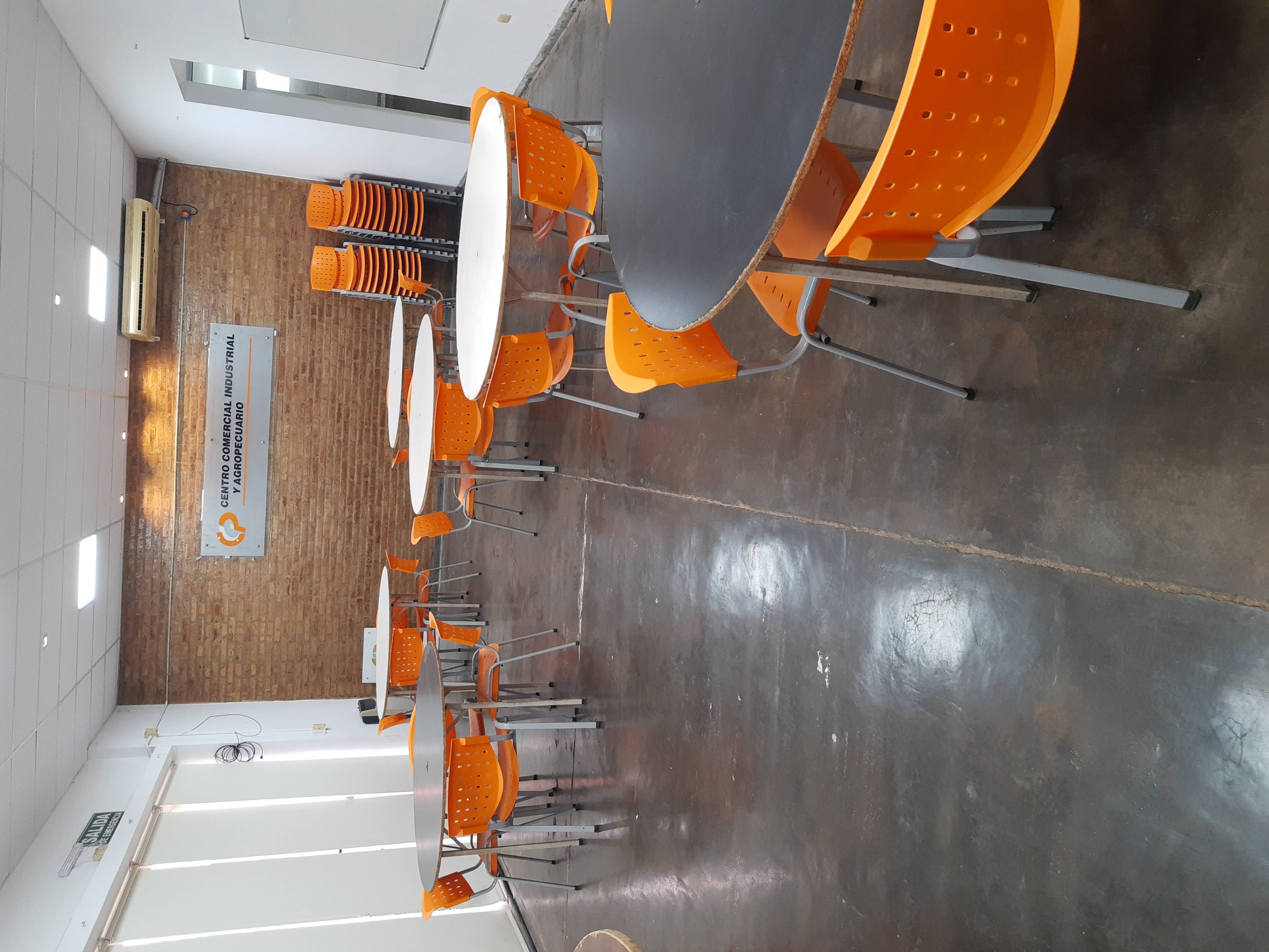 Salón con mesas y sillas naranjas