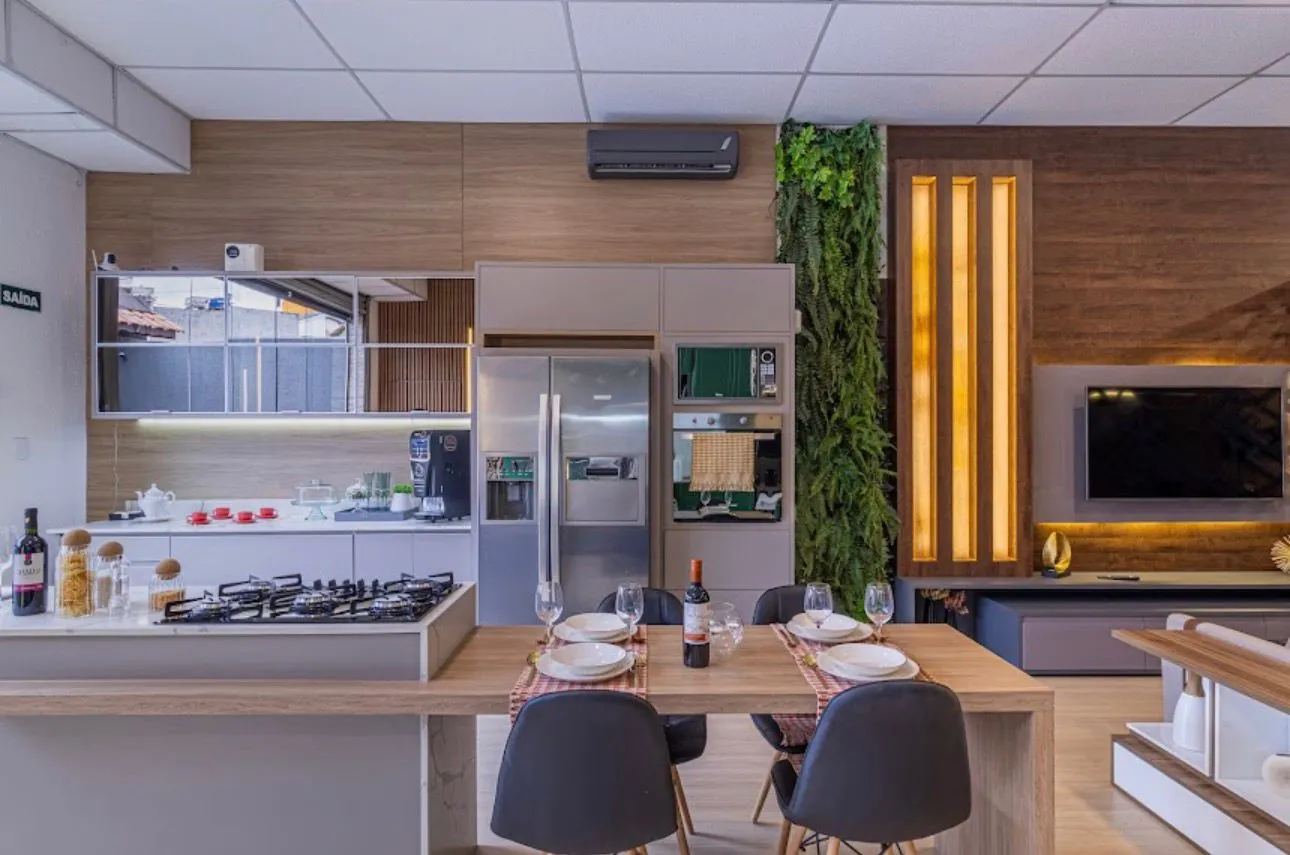 Cozinha e sala de jantar com jardim vertical e painel de TV iluminado