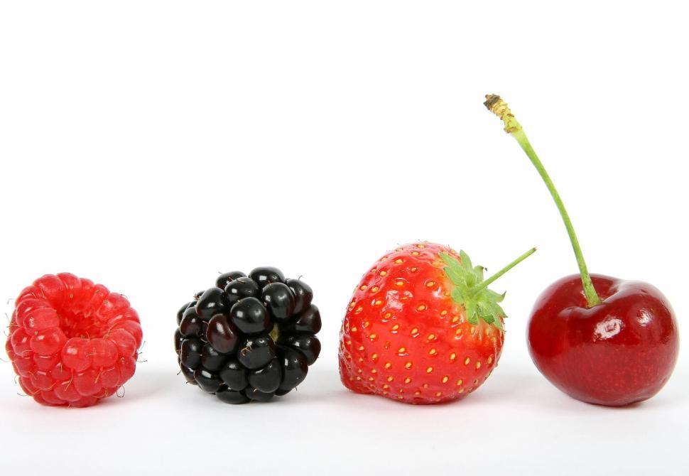 Four fruits in a row - raspberry, blackberry, strawberry, and cherry - on a white background for lasso tool practice