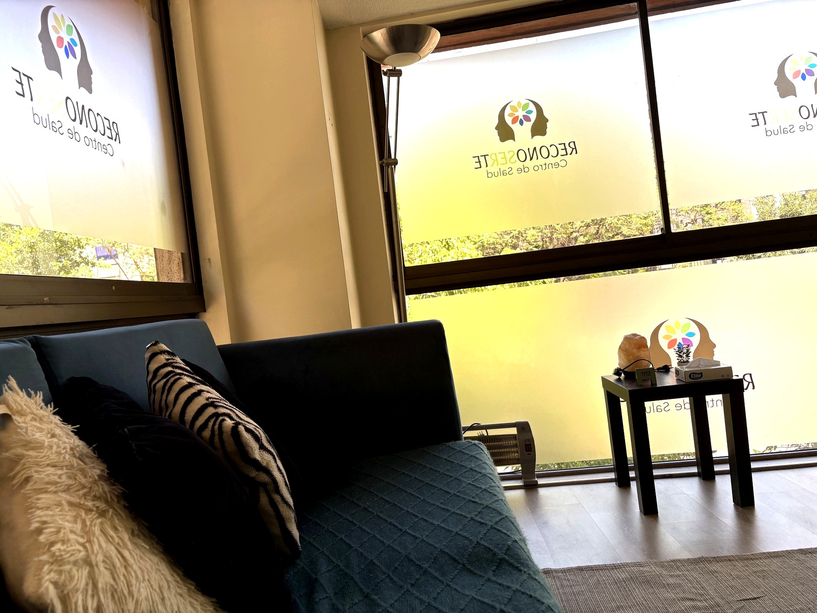 Sala de terapia con sofas azules y ventanas con logo de ReconoSERte