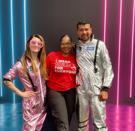 Three people in space costumes with neon lights backdrop Nashville photobooth