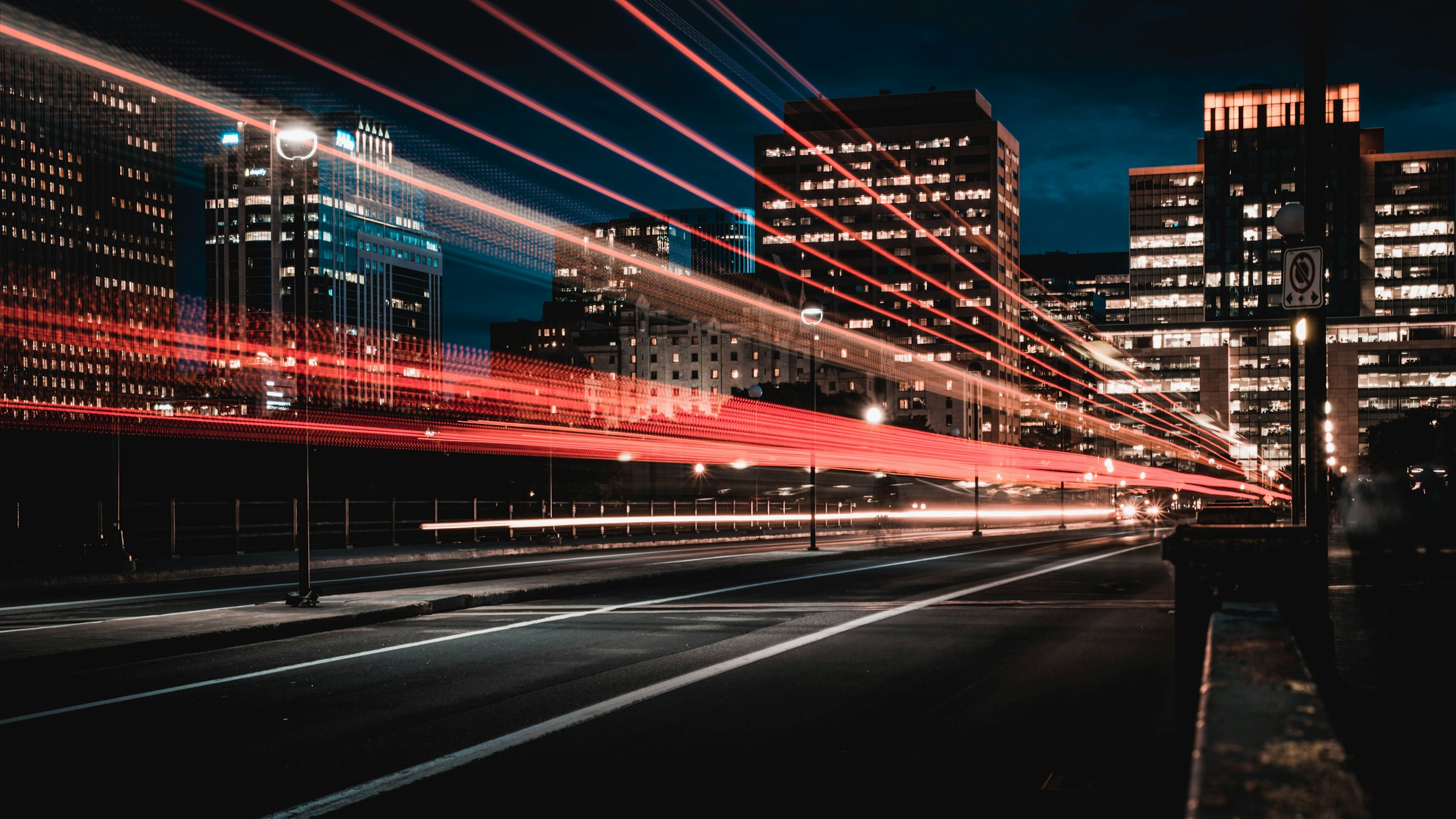 Long exposure night cityscape with red light trails from traffic