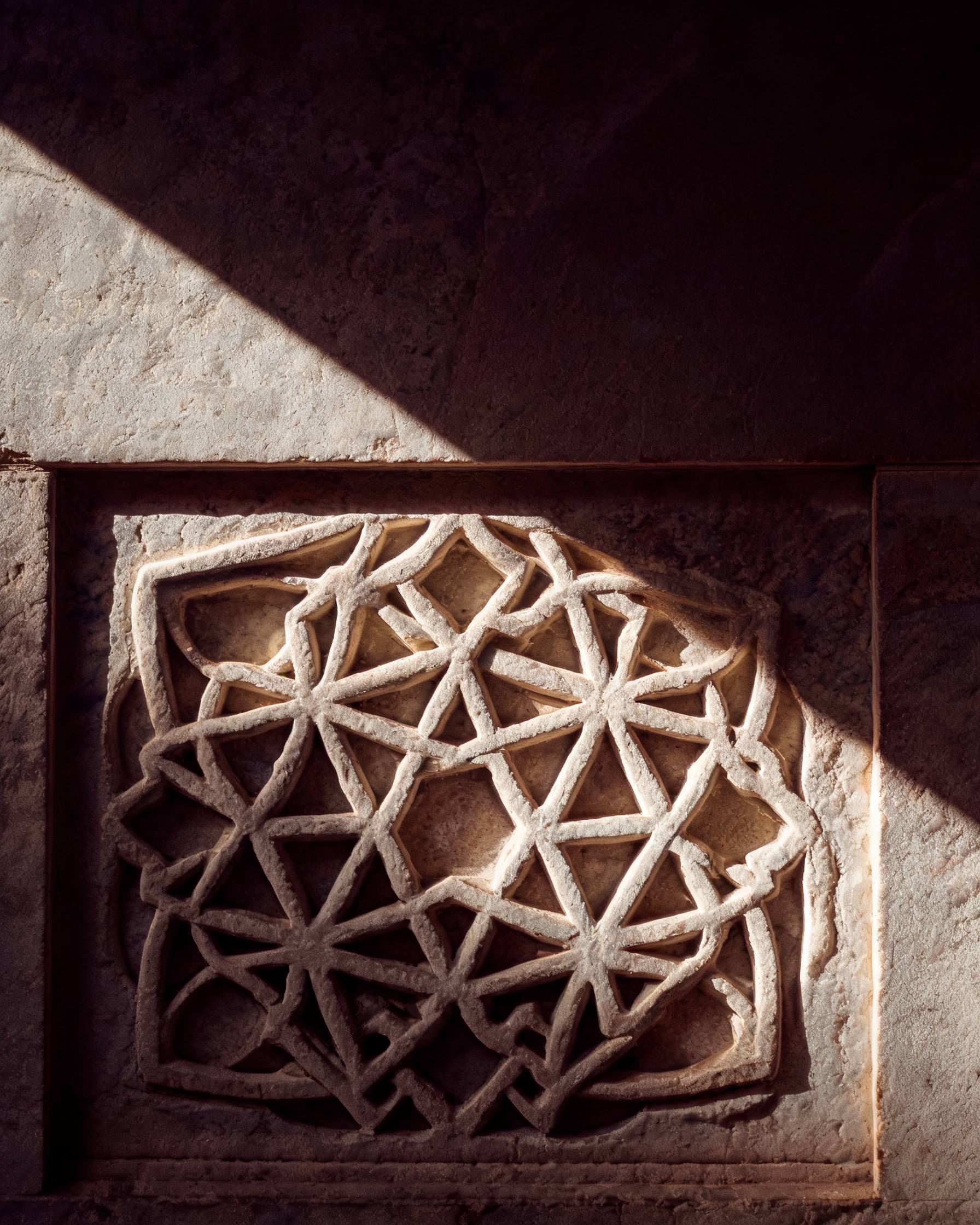 A single carved girih star tile detail lit by warm low-angle daylight