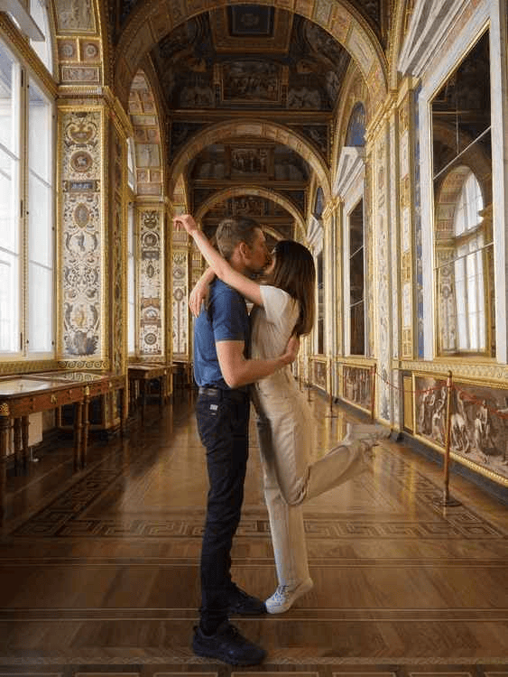Couple kissing in an ornate palace gallery