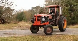 A red tractor doing a wheelie