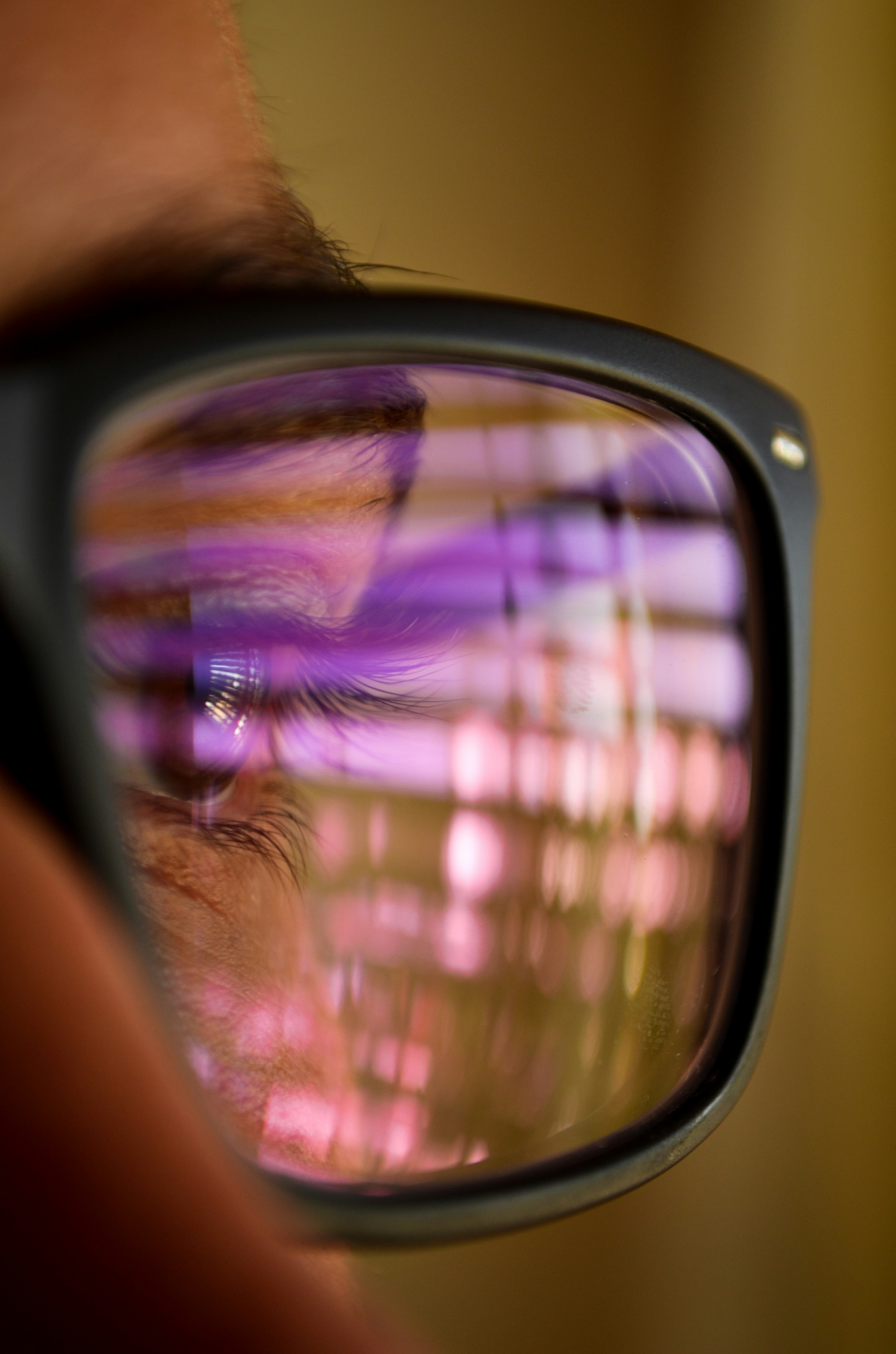 Close-up of blue light glasses lens showing purple reflection