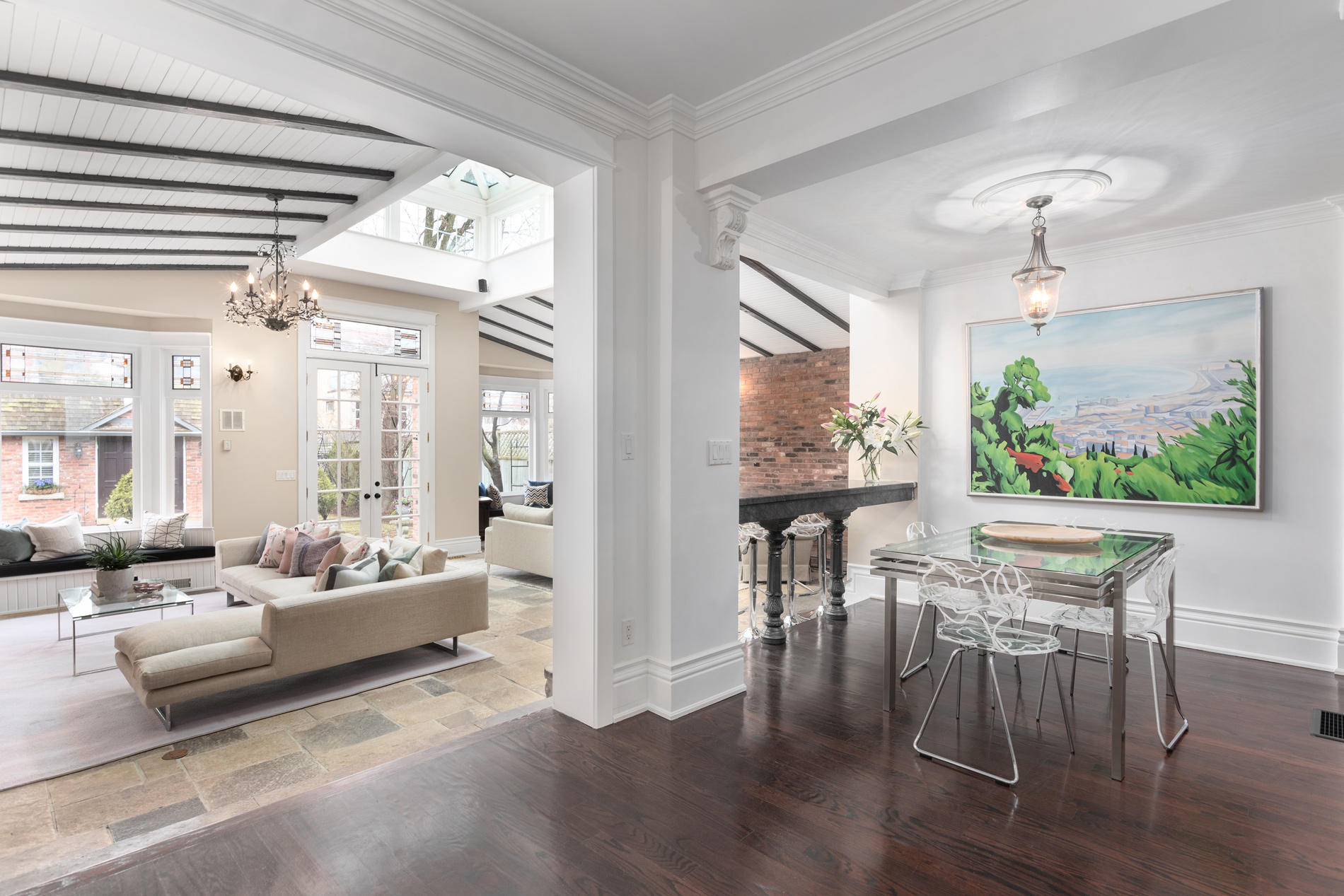 Bright traditional open floor plan home with beamed ceiling and elegant chandelier