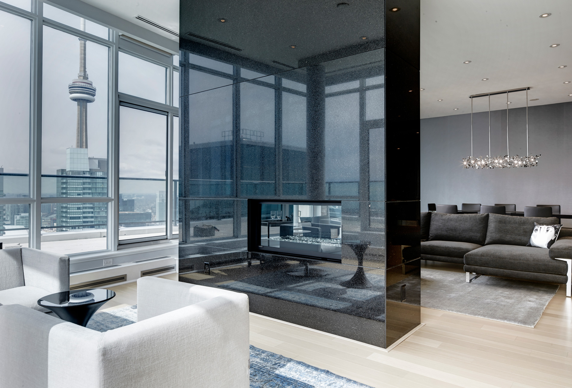 Modern luxury penthouse with CN Tower view and sleek black fireplace