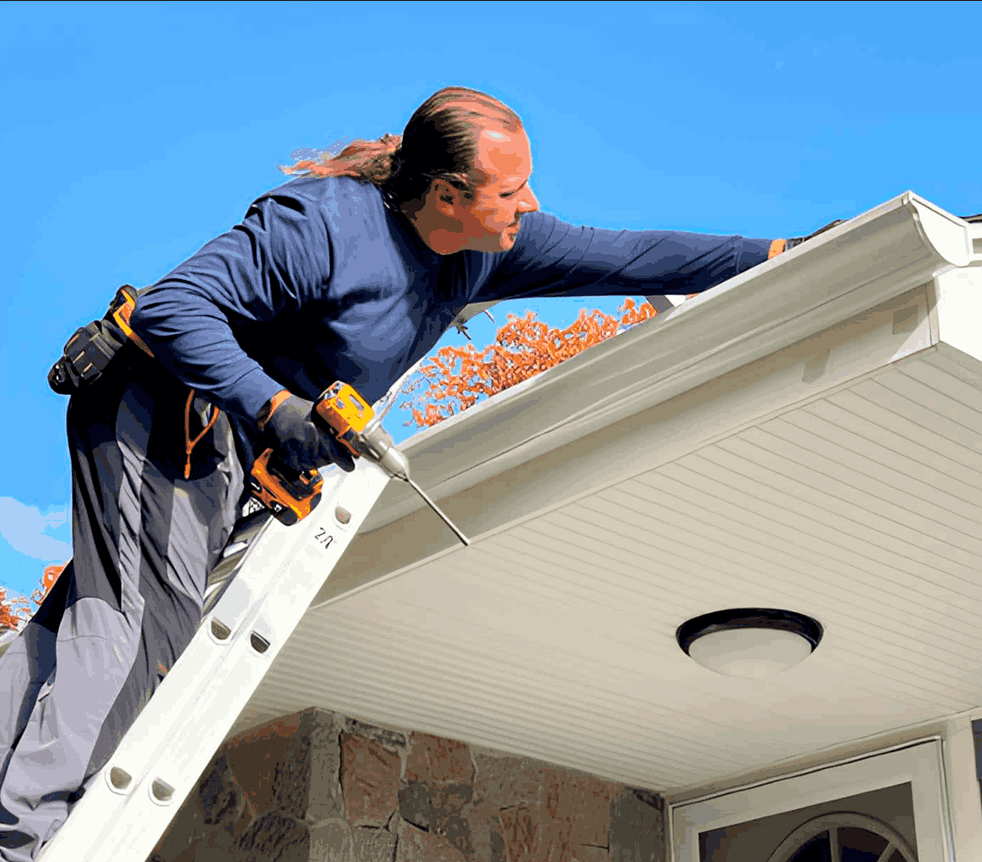 Professional gutter installer working on a residential home