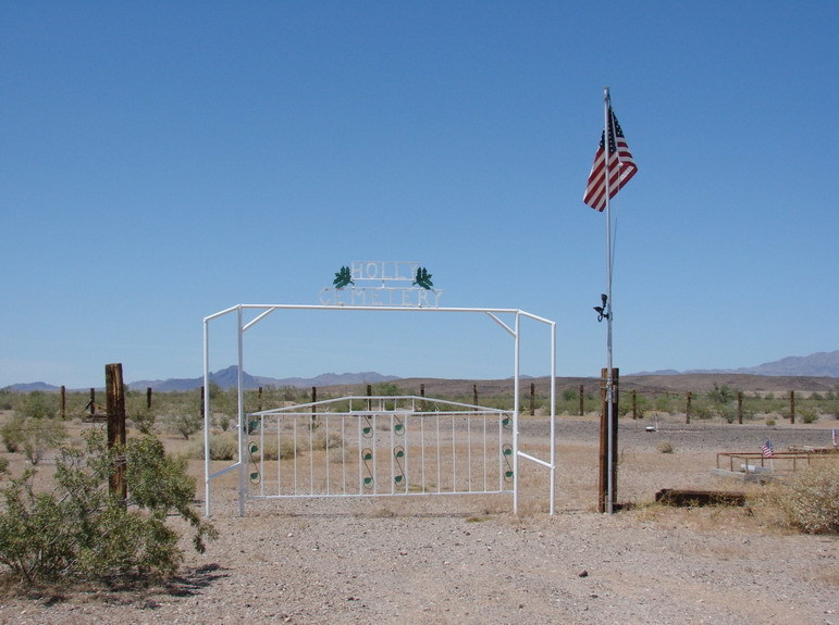 The white gate and American flag at Holly Cemetery in the Vidal desert