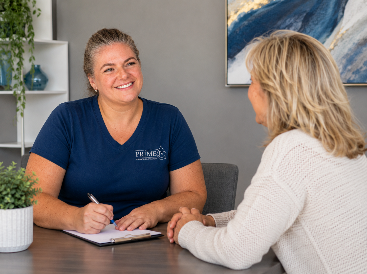 A Prime IV staff member in a branded shirt during a one-on-one hormone consultation with a client at Prime IV Flemington