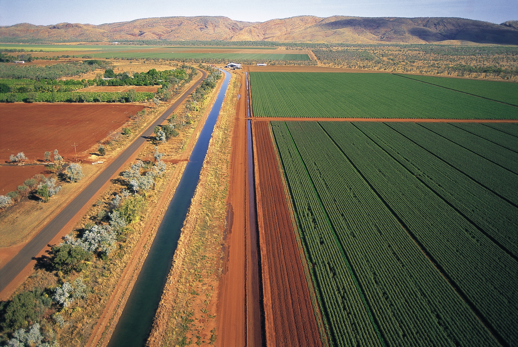 Aerial view of an Australian irrigation farming operation showing production blocks, irrigation channel and red-soil paddocks