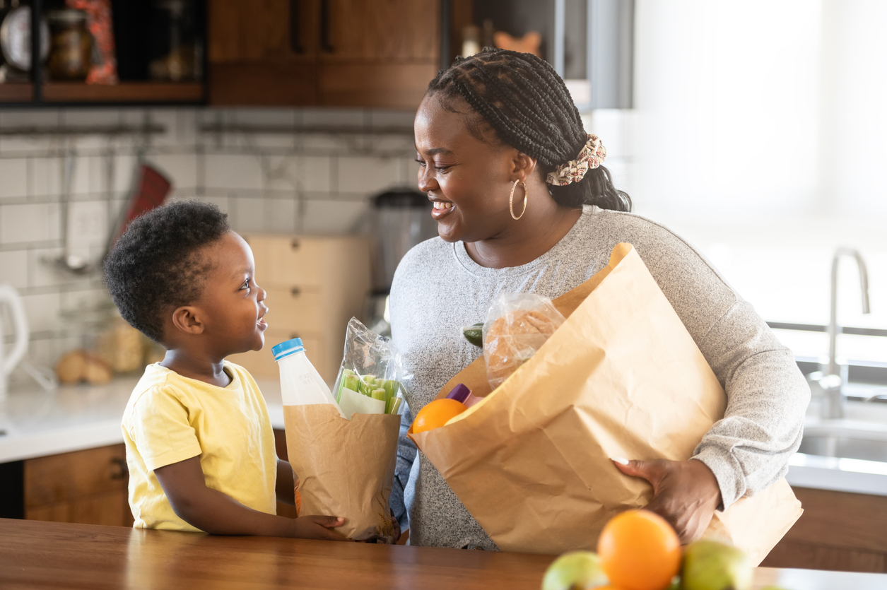 Mother and son unpacking groceries together