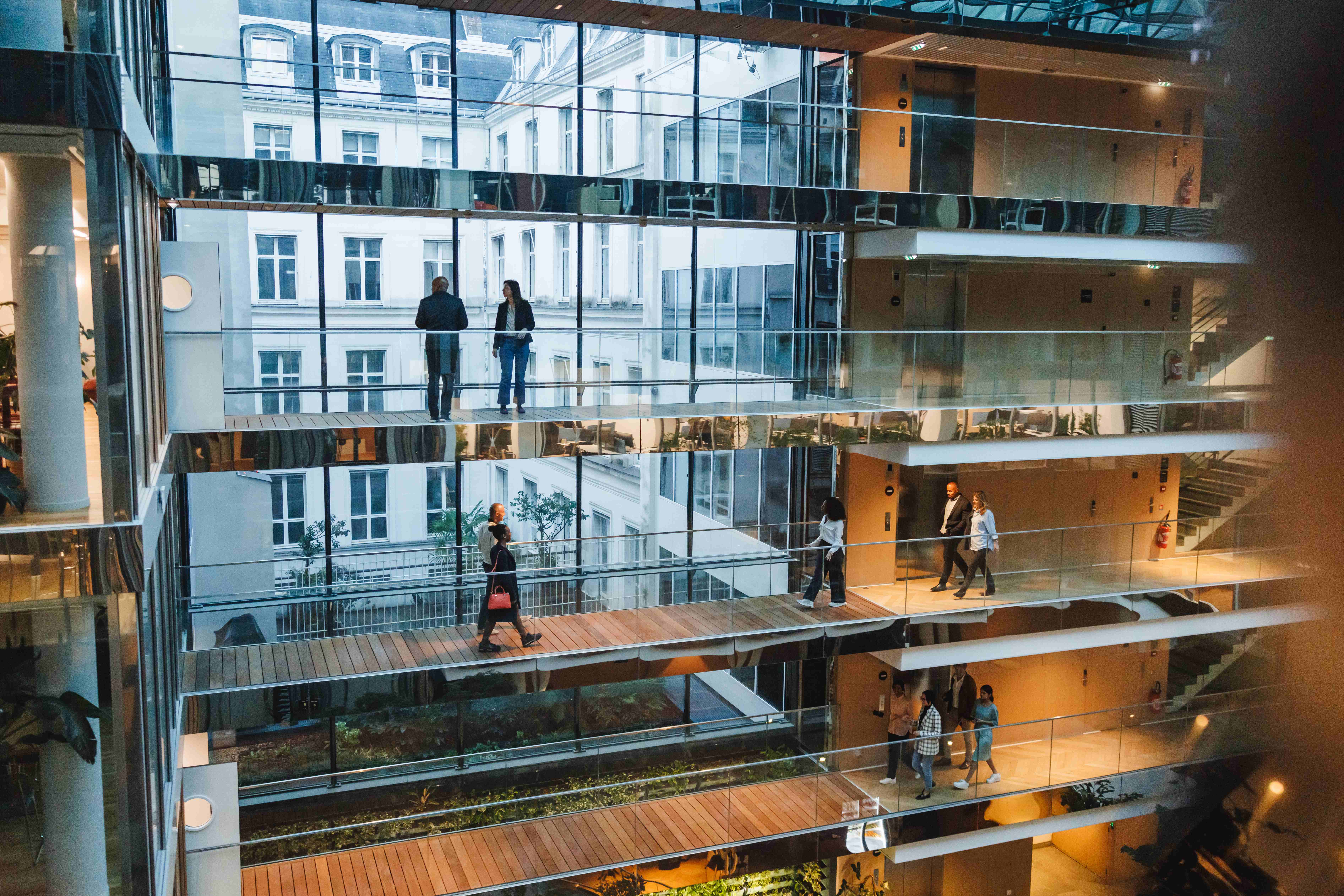 Modern multi-story office atrium with professionals in contemporary commercial spaces