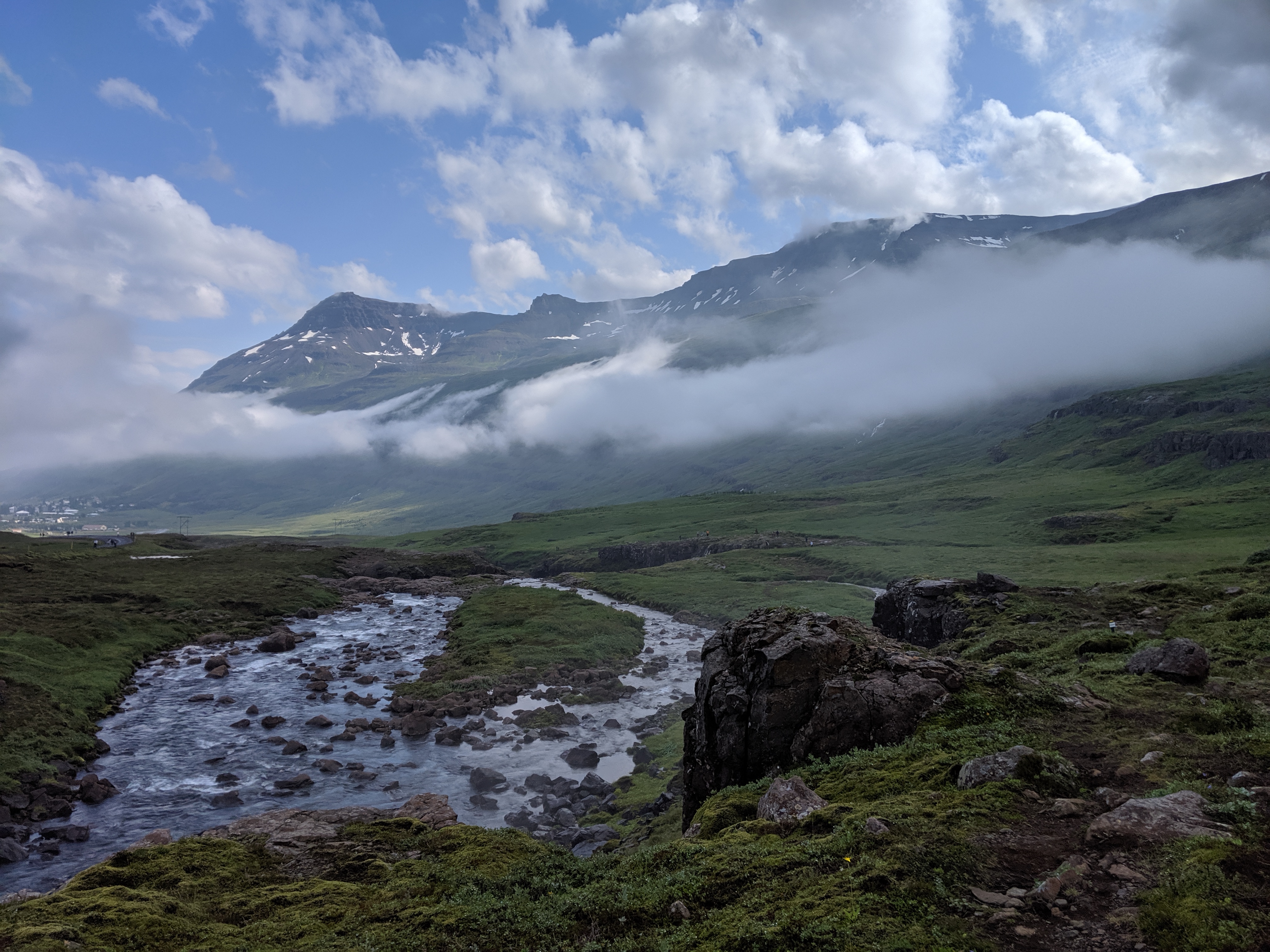 Dramatic Icelandic landscape with flowing stream and misty mountains