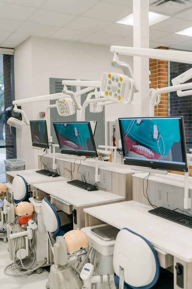 Dental simulation lab with mounted mannequins and monitors