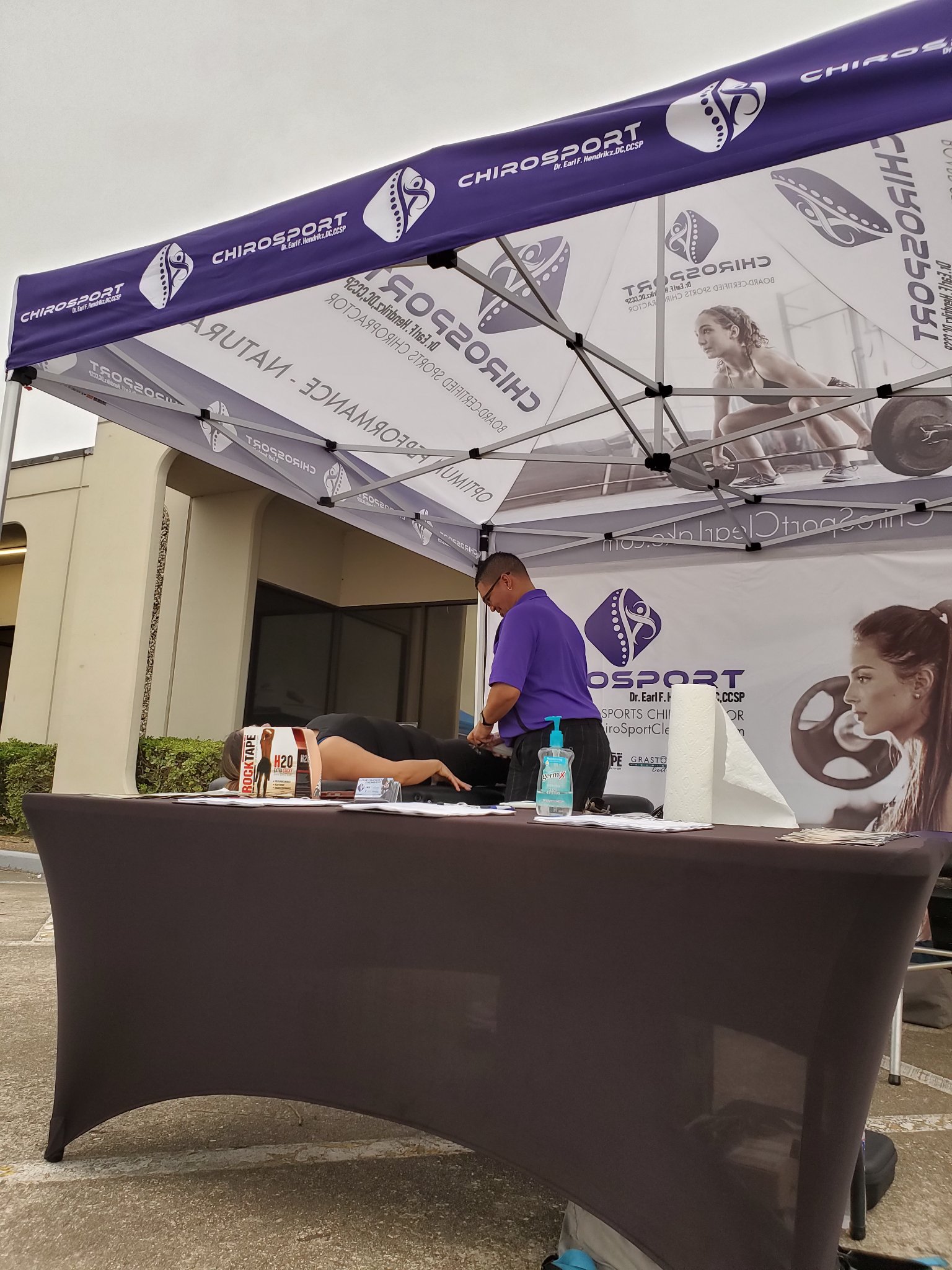 Dr. Hendrikz working on a patient lying face down at the event treatment booth