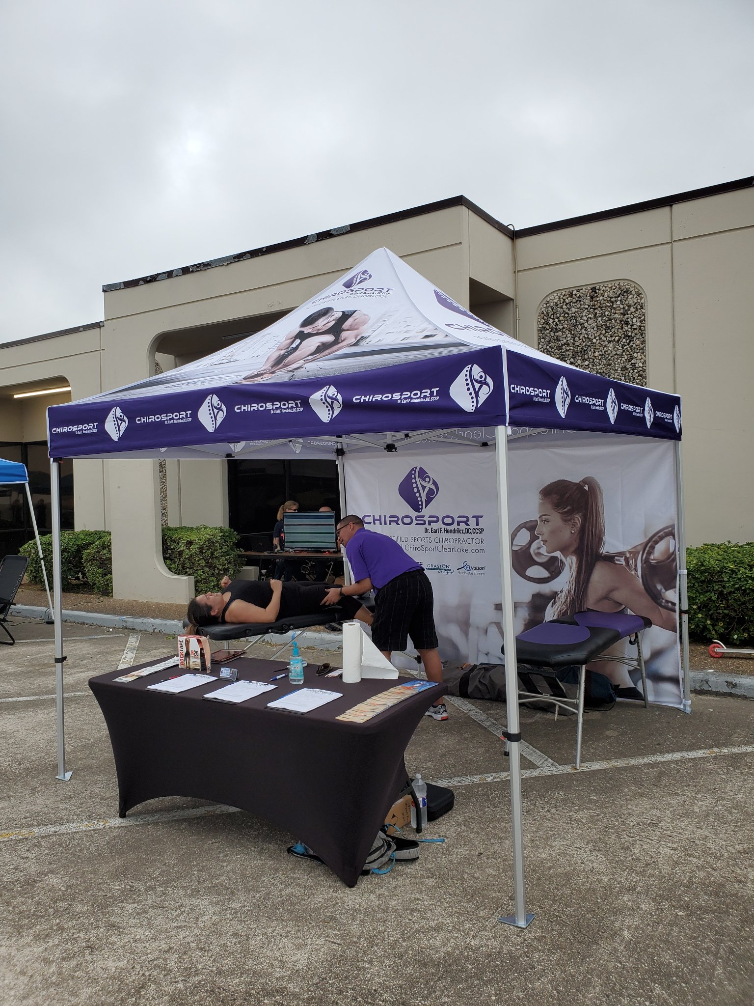 Wide view of the sports chiropractic booth with a practitioner treating a patient's leg