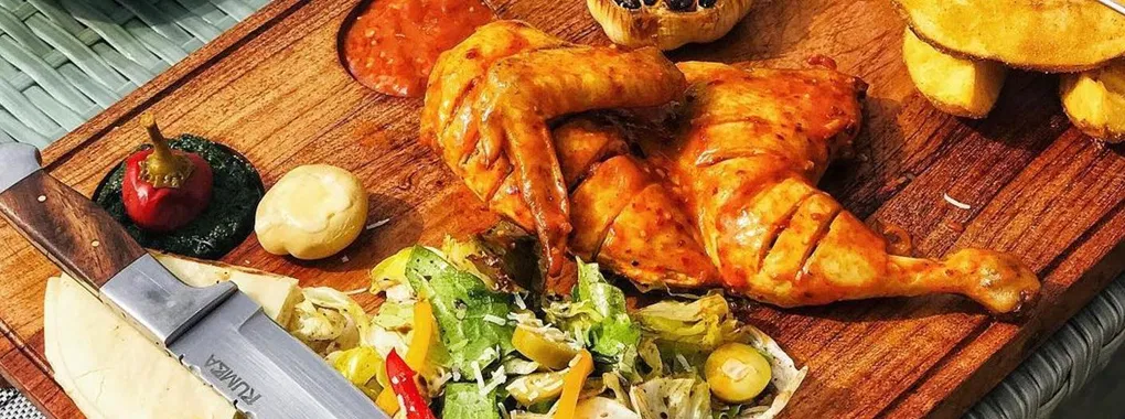 Flame-grilled chicken served on a wooden board