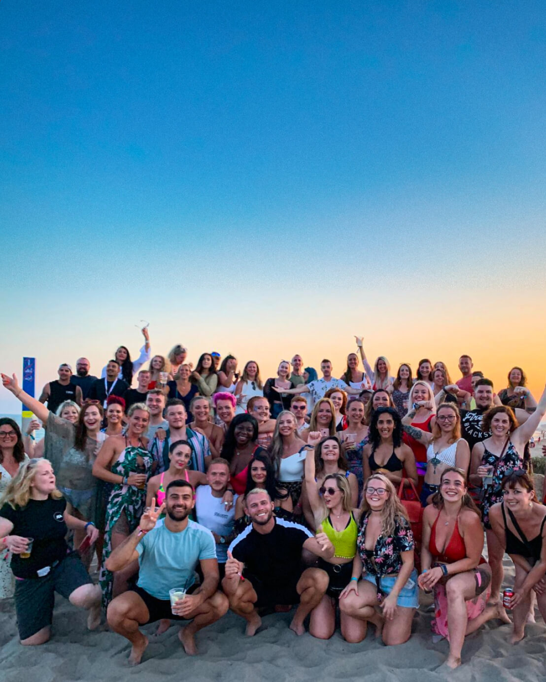 James Smith Academy community gathering on the beach at sunset