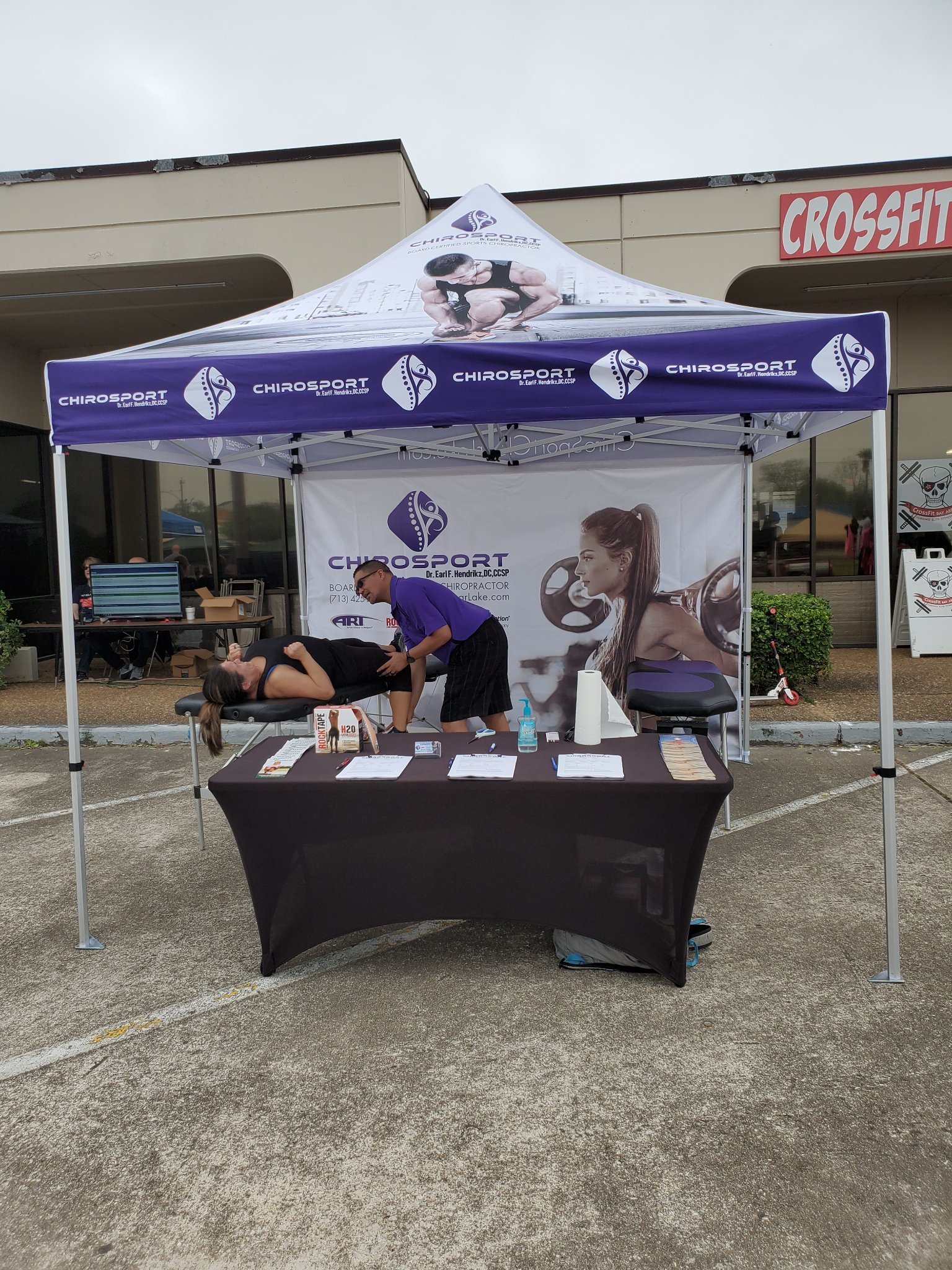 Wide view of the event treatment booth set up in front of a CrossFit gym