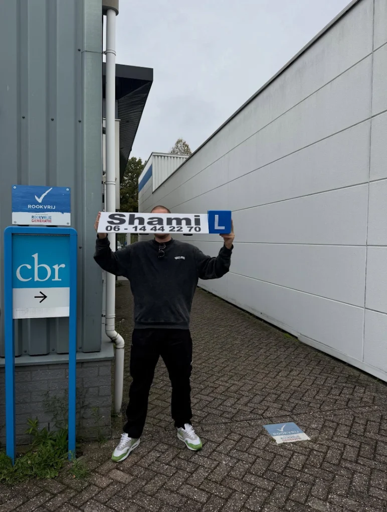 Geslaagde leerling bij het CBR met bord van Rijschool Shami