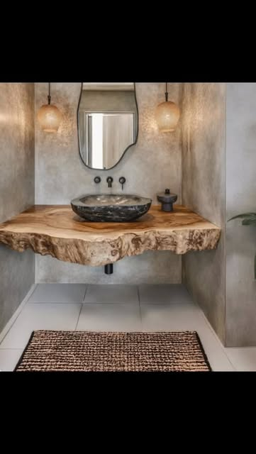 Luxury bathroom with live-edge timber vanity, black stone vessel sink, warm amber pendant lights, and textured concrete walls — homewares and accessories by Jayne Michelle Interiors
