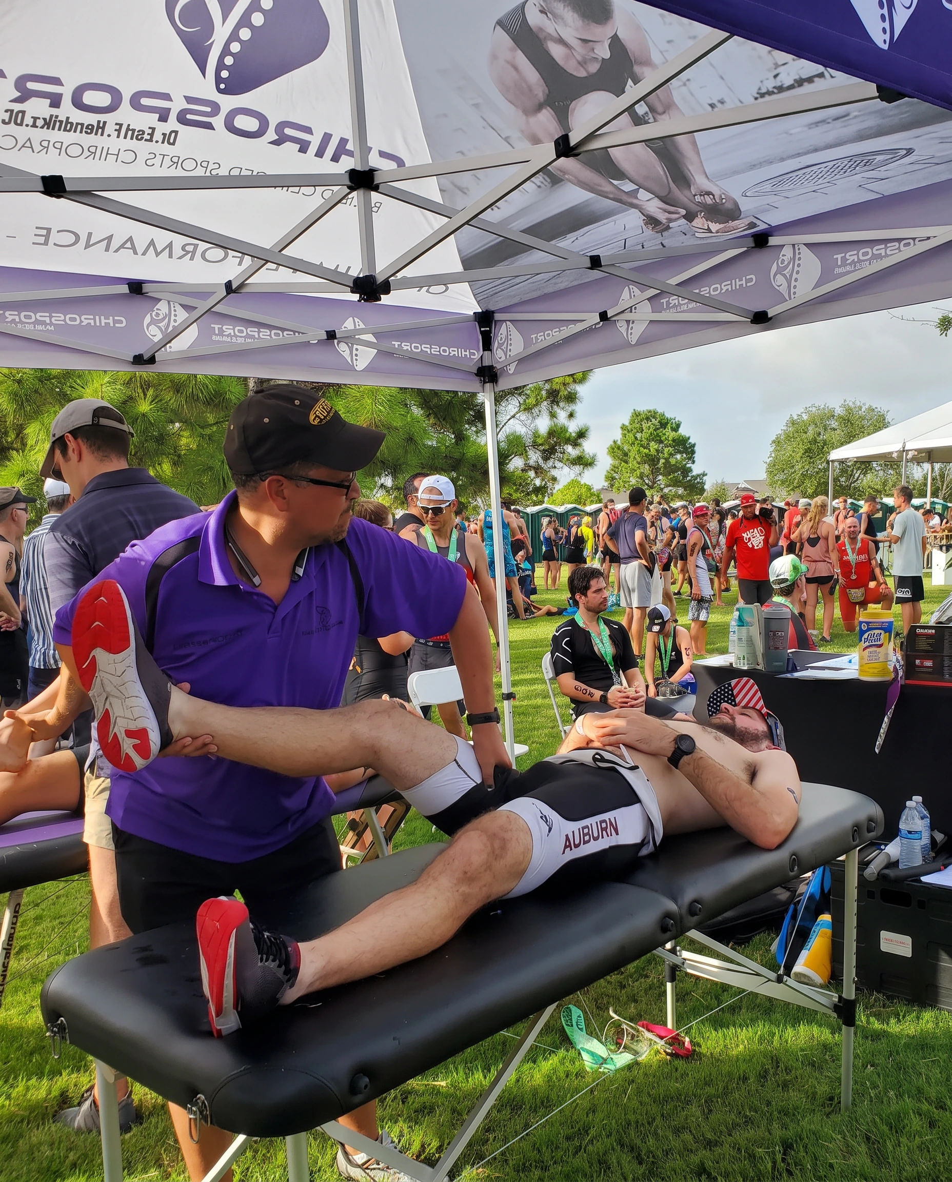 Dr. Hendrikz stretching a triathlete's leg on a treatment table at a triathlon