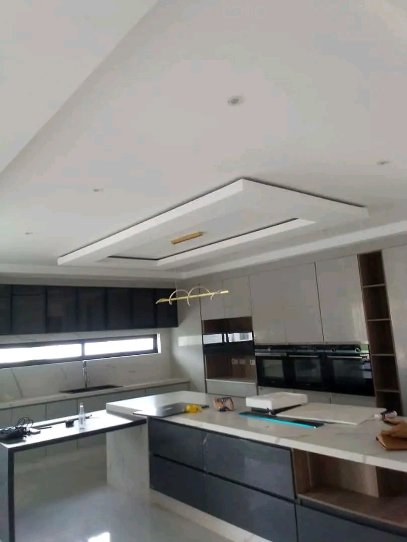 Open-plan kitchen with coffered ceiling, gold pendant and dark cabinetry