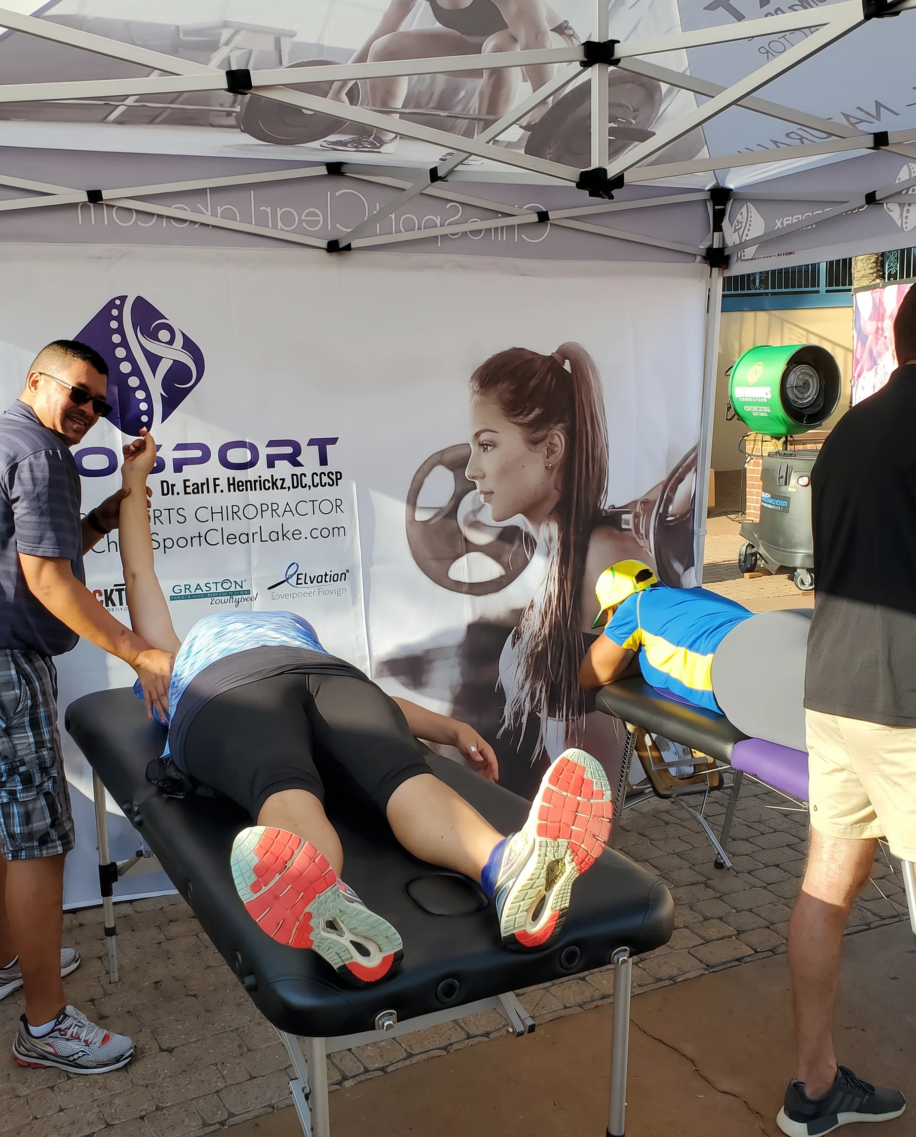 Dr. Hendrikz treating two patients on treatment tables at an outdoor event