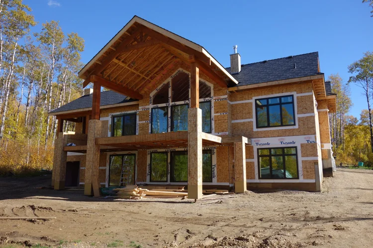 Two-story timber frame with covered deck in fall
