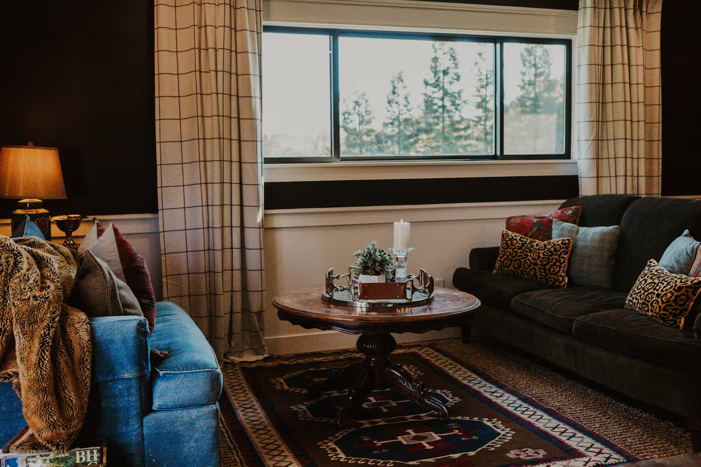 The bedroom at dusk with warm lamp light and layered linens