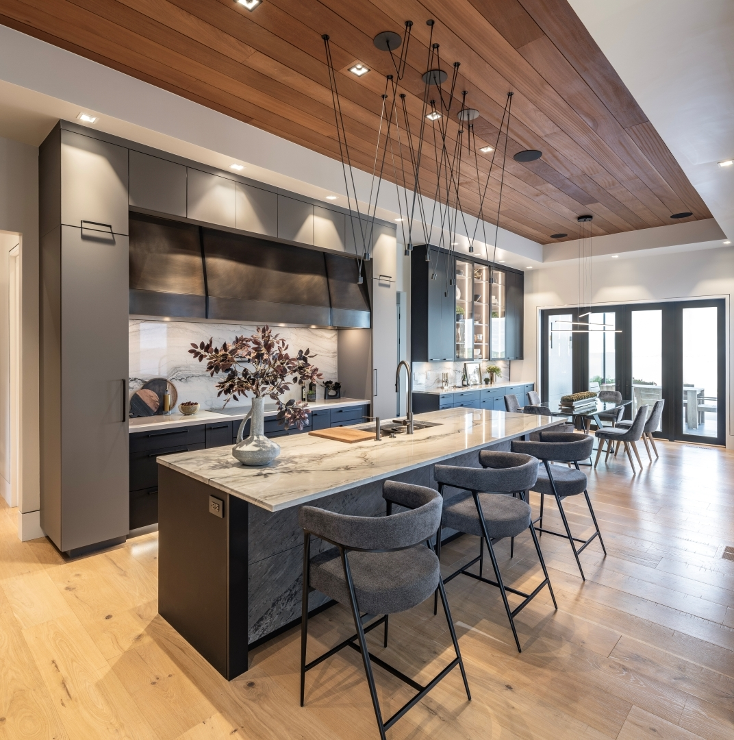 Dark luxury kitchen with marble island, wood ceiling and pendant cluster lights — Potomac