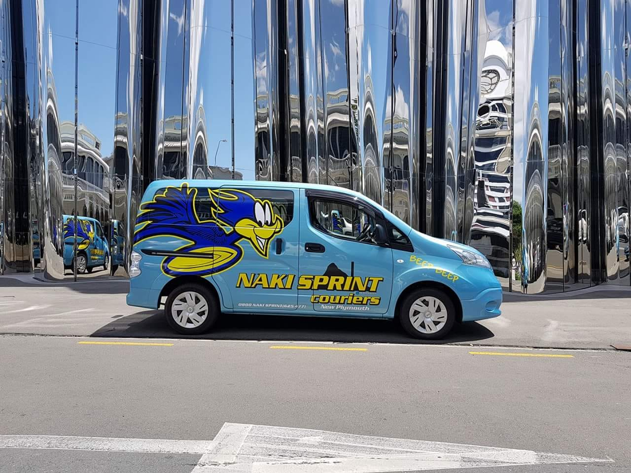 Naki Sprint Couriers branded delivery van - featuring the roadrunner mascot and company branding in front of the Len Lye Centre
