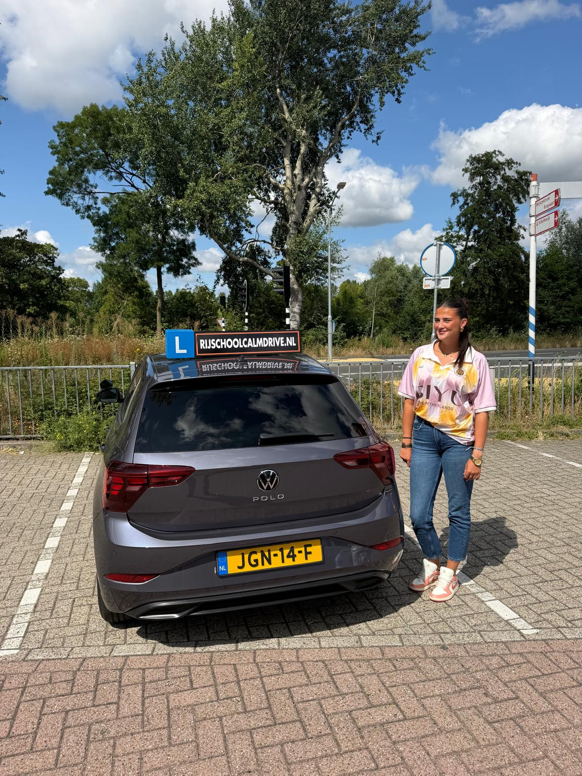 Leerling van Rijschool Calm Drive bij de lesauto in Amsterdam