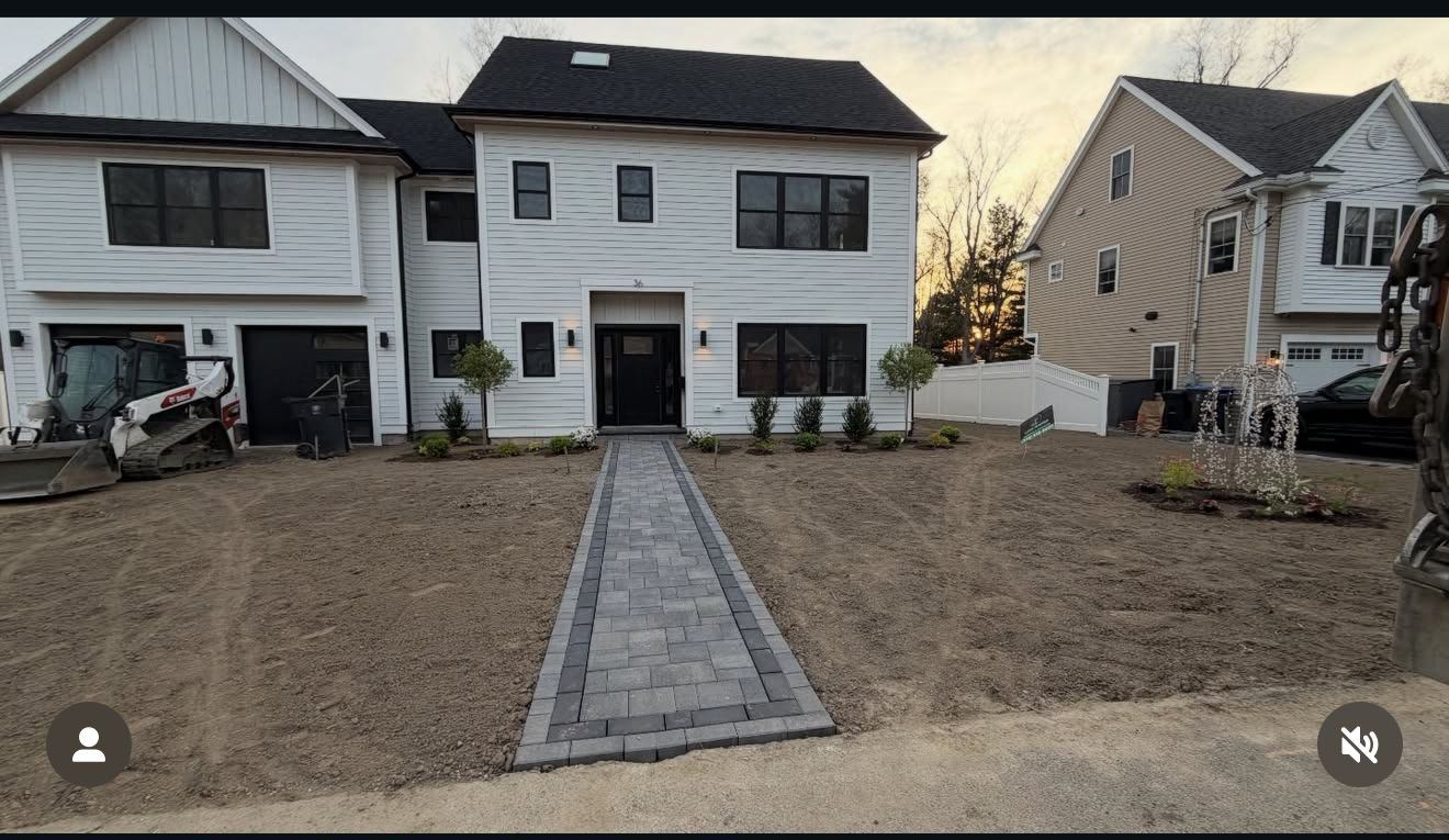 Symmetrical paver walkway leading to a modern white two-story home