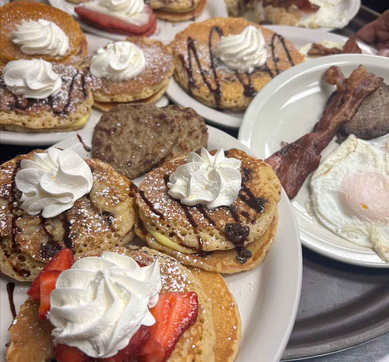 A spread of specialty pancakes, eggs, and bacon