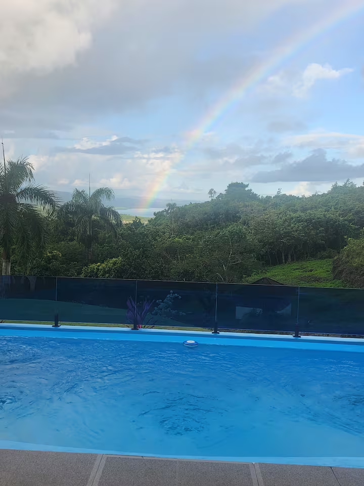 Vista mágica de la piscina con un arcoíris sobre el paisaje tropical