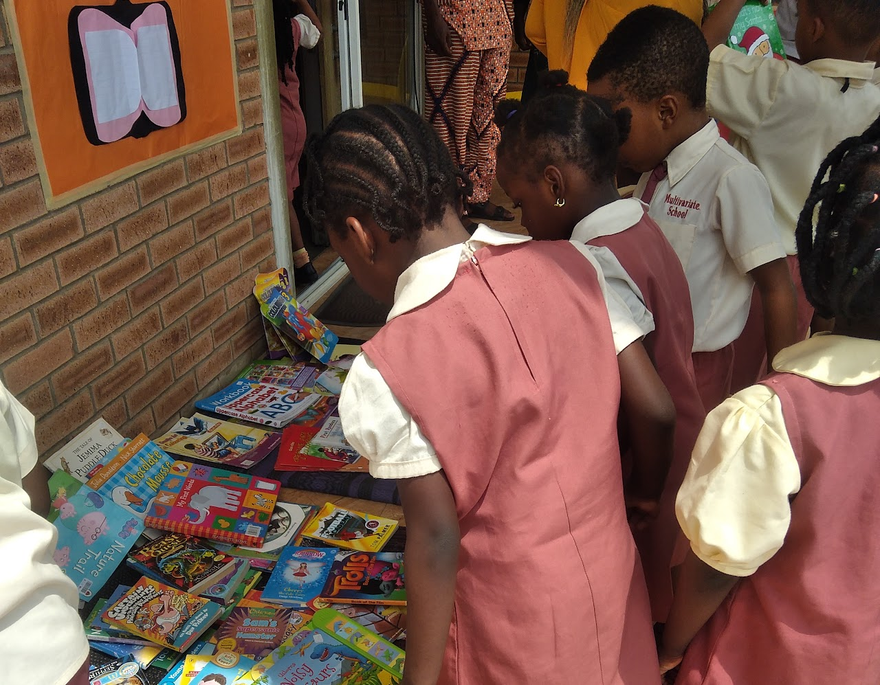 Pupils in uniform browsing books at a school book fair