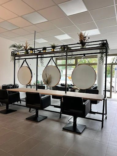 Salon Innenansicht Valessa Munich mit runden Hängespiegeln und schwarzen Stühlen