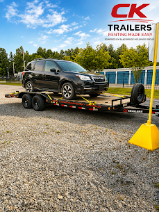 Black SUV loaded on CK Trailers car hauler trailer at professional rental facility with CK Trailers branding