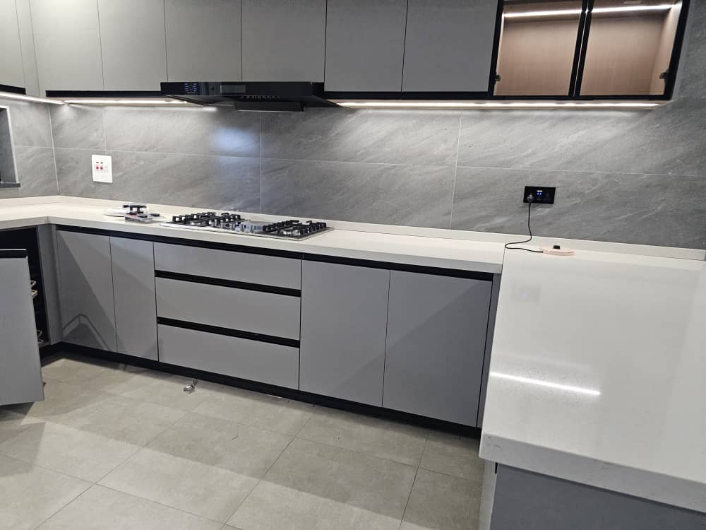 Grey kitchen with under-cabinet LED strip lighting and gas hob