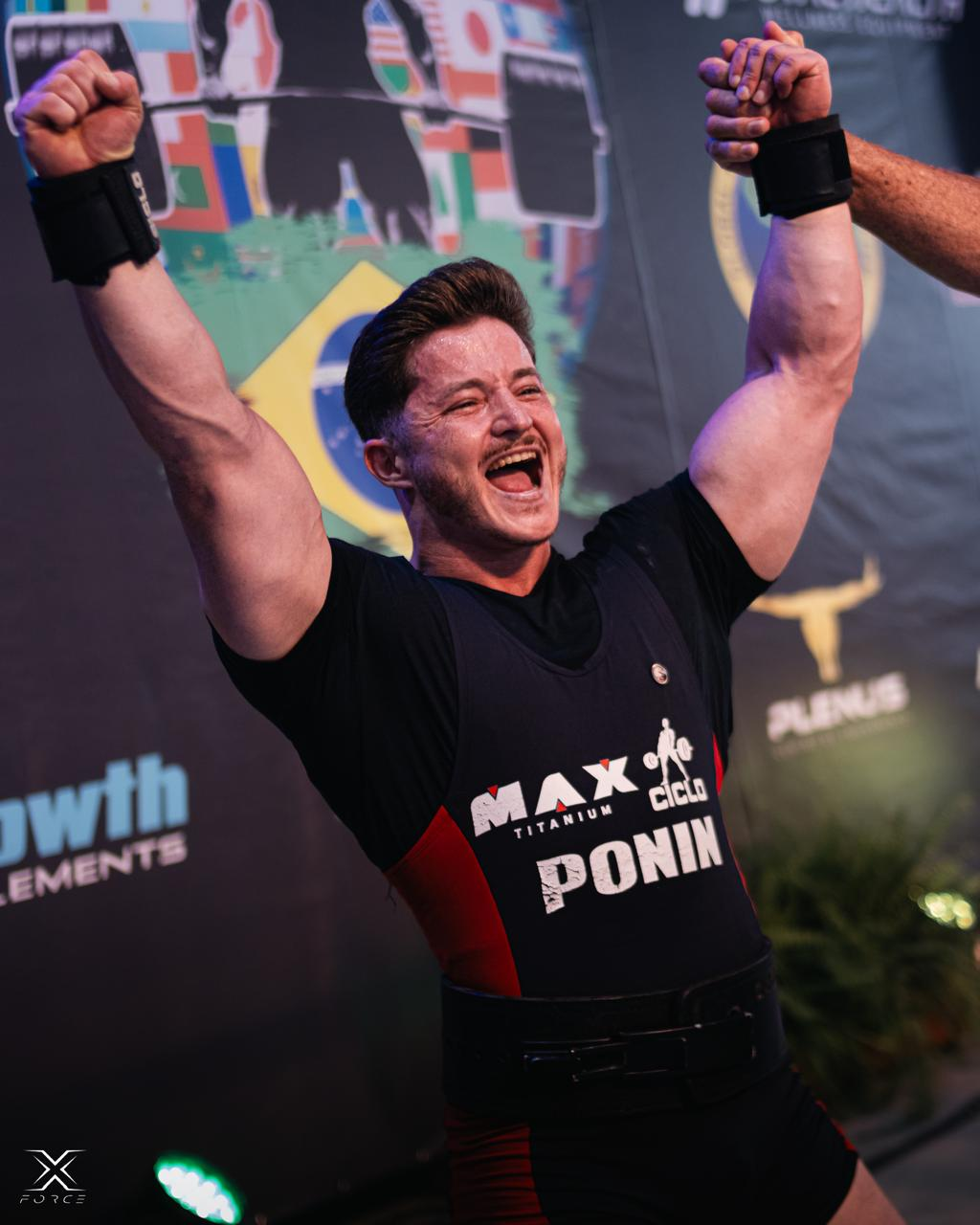 Ponin celebrando com bracos erguidos e bandeira do Brasil