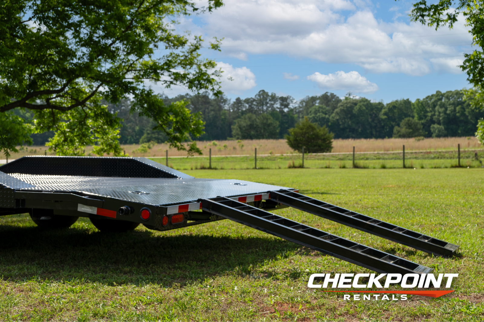 Car hauler low rear-angle showing extended loading ramps