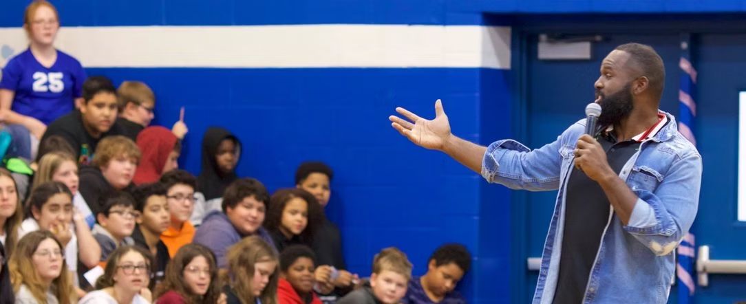 Pro athlete speaking to students during assembly