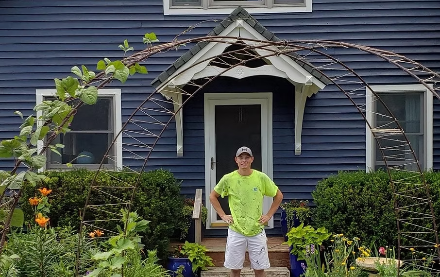 Hoyt Grooms, owner of G10 Painting Services, standing proudly in front of a completed project